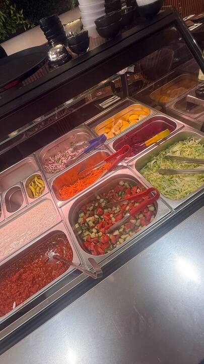 Fresh salad bar with tomato, cucumber, cabbage, carrot and red onion